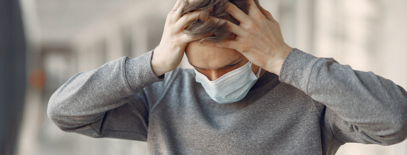 Burnout A man wearing a mask to protect from COVID-19, but also stressed out.