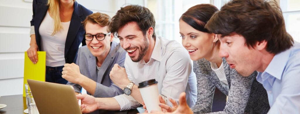 A happy team working together on a laptop