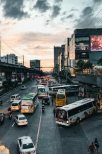 A busy road in a city with cars, buses, and taxis.
