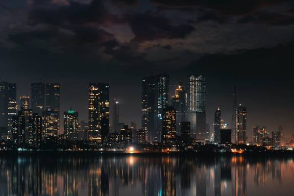 Another city by the riverside at night.