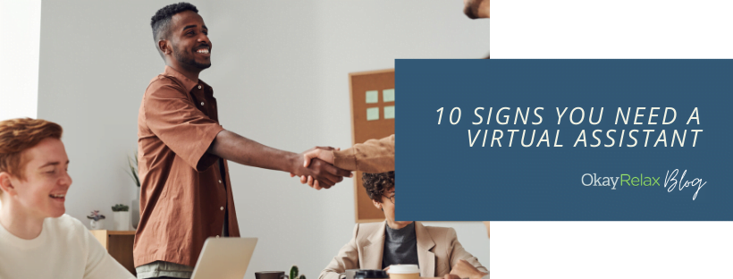 A person getting a handshake from an officemate. Other office people are sitting nearby. The blog title reads at the right, "10 Signs You Need A Virtual Assistant".