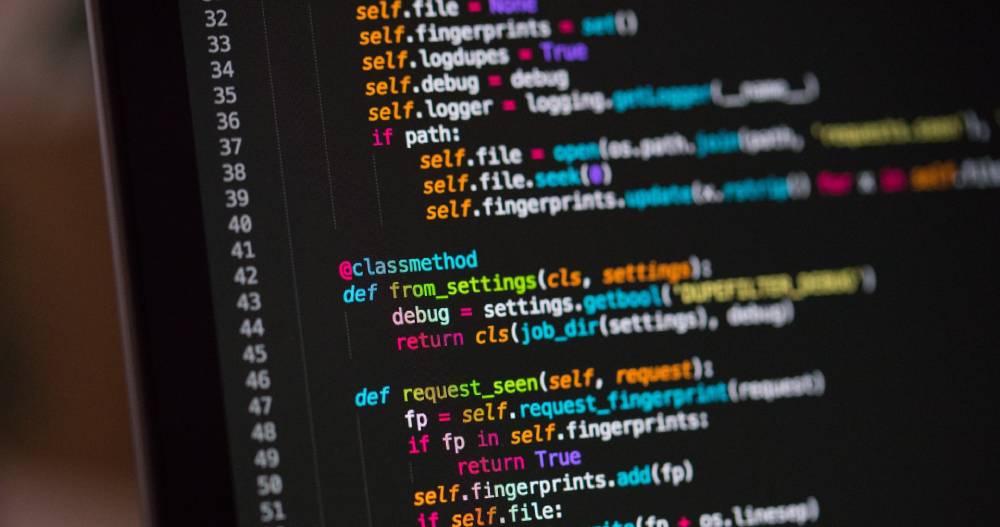 A laptop screen showing lines of code.