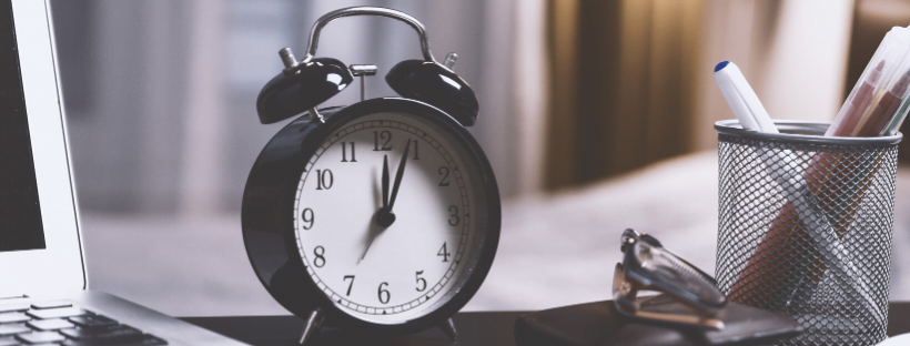 An analog clock on a desk.