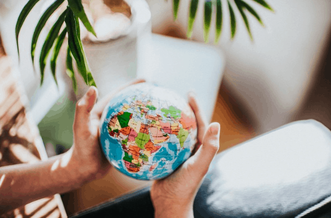 A person holding a toy globe.