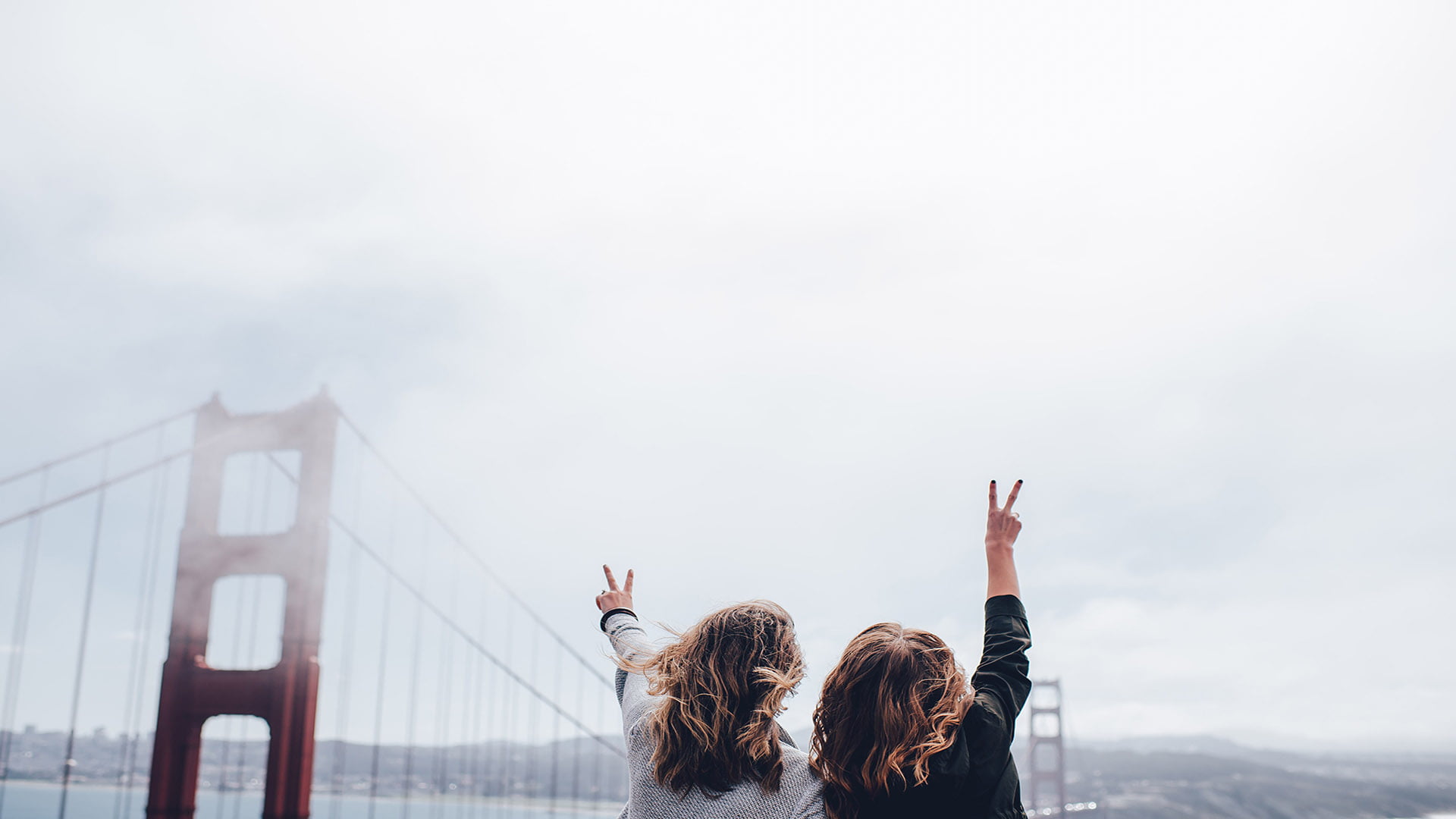 a couple of people standing in front of a bridge